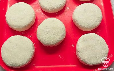 Расплюсните шарики до толщины примерно 1 сантиметр и обваляйте в муке или манке.