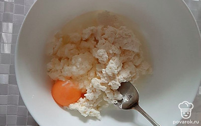 К творогу добавить 1 яйцо и тщательно перемешать.