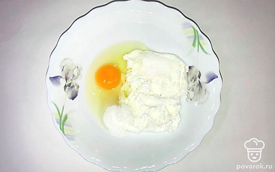 Возьмите посуду, добавьте туда творог и тщательно разомните его вилкой. Затем добавьте к творогу яйцо, ванильный сахар или ванилин, сахар и 3 ложки муки, тщательно перемешайте до получения творожного теста.