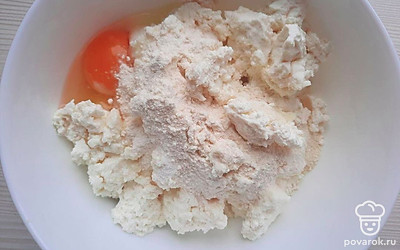 В емкость с творогом вбейте яйца, добавьте сахар, тщательно перемешайте, после просейте муку с разрыхлителем, снова перемешайте. Влажными руками возьмите немного теста, сформируйте сырник обваляйте в муке.