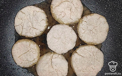 По истечению времени достаньте тесто, раскатайте и порежьте его кусочками, сформируйте кружки, обваляйте в муке. Возьмите сковороду, растопите в ней на плите масло, аккуратно поместите сырники, обжарьте с двух сторон до золотистого цвета. Перенесите их на тарелку с салфеткой, чтобы стек лишний жир.