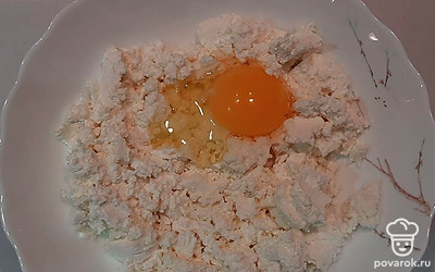 В глубокую емкость поместите творог, разомните его вилкой, вбейте куриное яйцо, тщательно перемешайте, после добавьте сахар, постепенно добавляйте муку. Повторно перемешайте. Разделите тесто на кусочки одинакового размера, немного приплюсните.