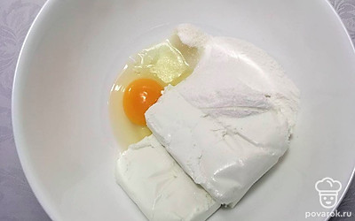 Возьмите глубокую емкость, поместите в нее творог, добавьте все по списку ингредиенты, взбейте миксером до однородной массы. Возьмите противень, застелите его бумагой для выпечки, смажьте маслом.