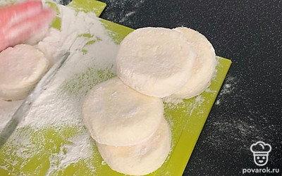 Смачиваем руки водой и формируем сырники, чтобы масса не прилипала к рукам. Формируем несколько равномерных шариков, обваливаем в муке, придаем форму. 