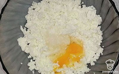 Возьмите глубокую емкость, поместите в нее творог, тщательно разотрите, вбейте яйцо, добавьте соль и сахар, тщательно перемешайте, до однородного состояния. Просейте муку, повторно перемешайте.