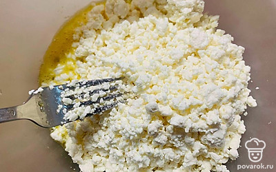 Положите творог, тщательно разбейте все комочки вилкой.