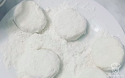 На плоскую тарелку высыпаем оставшуюся муку и манную крупу, перемешиваем. Из творожной массы формируем сырники и обваливаем в получившейся смеси.