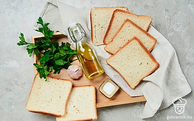 При необходимости нарежьте тосты на ломтики толщиной 1-1,5 см. Чеснок очистите и пропустите через пресс. Сыр натрите на мелкой терке. Разогрейте духовку до 190 градусов. Петрушку ополосните, обсушите, разложив на полотенце. Оставьте несколько листочков для подачи, остальное измельчите с помощью ножа или блендера.