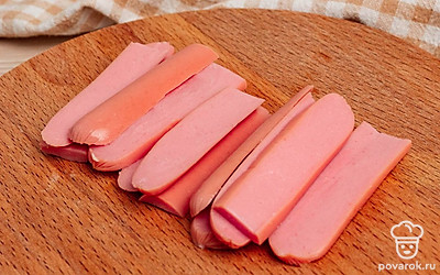 Сосиски нарежьте вдоль тонкими полосками.