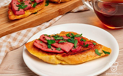 Снимите гренки со сковороды и переложите в порционную тарелку. Посыпьте мелко рубленной петрушкой. Подавайте горячими к чаю или кофе.