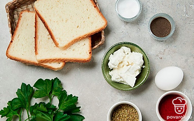 Помойте яйцо. Нарежьте хлеб тонкими ломтиками толщиной 1-1,5 см. Зелень ополосните, выложите на полотенце и обсушите. Затем мелко нарубите ножом, оставив одну веточку для украшения. Подготовьте противень и пергамент. Разогрейте духовку до максимальной температуры (200-230 градусов). При возможности используйте режим гриля.