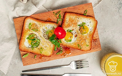 Украсьте готовые тосты с перепелиным яйцом половинками помидоров черри и листочками базилика.