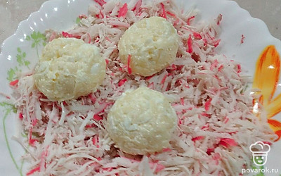 Из сырной массы сформируйте шарики. Обваляйте их в крабовых палочках. Уберите в холодильник на 1 час.