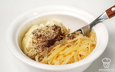 Приготовьте начинку для тостов. Смешайте в миске тертый пармезан и чеснок, добавьте майонез, поперчите и хорошо перемешайте массу.