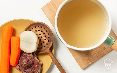 Приготовьте холодец с морковью. Из бульона шумовкой достаньте мясо, морковь и лук. Отделите 500 мл (2 стакана) бульона, поставьте на медленный огонь, влейте желатин. Перемешайте. Нагрейте жидкость, чтобы загуститель растворился.