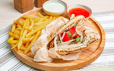 Греческие гирос переложите на блюдо, украшенное молодым зеленым луком. Подавайте к столу вместе с картофелем фри, соусом дзадзики и соусом чили.