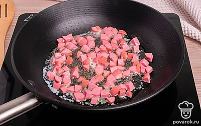 Обжарьте сосиски в сковороде на сливочном масле.