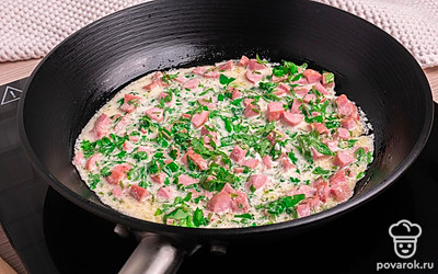 Добавьте в сковороду сметану, воду и нарезанную зелень. Перемешайте и тушите до готовности в течение 5-7 минут.