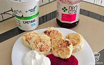 Выложите сырники на тарелку. Добавьте сметану и варенье.