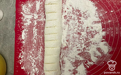 Рабочую поверхность посыпьте мукой. Из творожной массы сформируйте колбаску, разделите ее на 10-11 частей. Это зависит от того, какого диаметра сырники вы хотите.