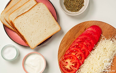 Приготовьте начинку. Сыр натрите на мелкой терке. Помидор нарежьте тонкими кружочками. Нарезанные кусочки томатов желательно высушить, аккуратно протерев бумажным полотенцем с двух сторон.