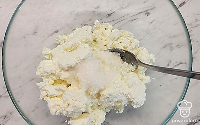 В миске разомните 400 грамм творога с 2 столовыми ложками сахара и щепоткой соли.