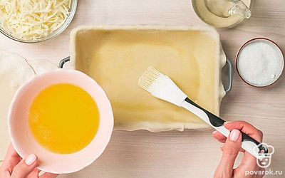 Начните формирование ачмы. Разделите тесто на 8 частей, каждую из которых раскатайте тонко в круг, который по размеру должен быть чуть больше формы для запекания. Форму обильно смажьте маслом. Выложите первый слой. Снова щедро смажьте маслом.