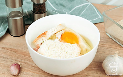 Фарш выложите в миску. Добавьте к нему лук, чеснок, замоченный хлеб, яйцо, соль и перец по вкусу.