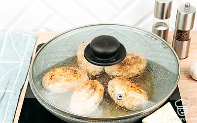 Переверните котлетки, накройте крышкой, жарьте еще 5-7 минут.