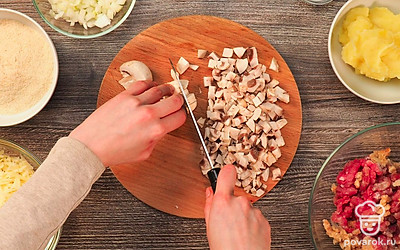 Вымойте и почистите лук и чеснок. Через мясорубку пропустите мясо индейки, одну луковицу, чеснок и белый хлеб. Вторую луковицу мелко нарежьте. Шампиньоны, вымойте, обсушите на бумажных полотенцах и нарежьте кубиками. Сыр натрите на крупкой или средней терке.