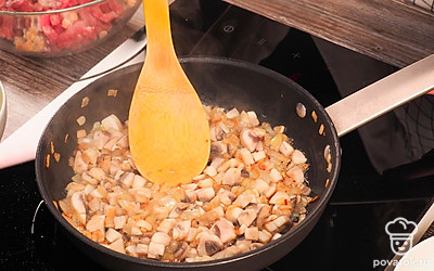 Обжарьте шампиньоны. Для этого поставьте на средний огонь сковороду, влейте растительное масло и добавьте лук. Обжарьте лук до золотистости и добавьте шампиньоны. Жарьте до испарения жидкости из шампиньонов. Ориентировочное время приготовления 7-10 минут.