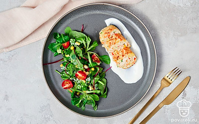 Котлеты из куриного фарша с кукурузой на тарелке, застеленной листьями салата.