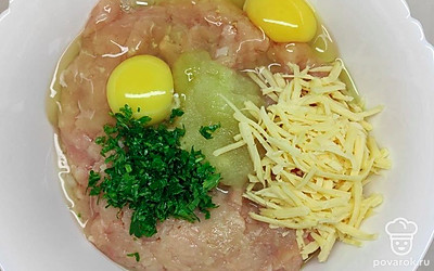 В глубокую миску выложите фарш. Добавьте к нему яйца, масло и специи по вкусу. Лук натрите в пюре, зелень мелко покрошите и выложите к фаршу. Хорошо перемешайте полученную смесь.