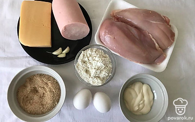 Промойте хорошо под холодной водой куриное филе. Ветчину и сыр натрите на терке. Подготовьте тарелку, куда будете выкладывать готовые котлеты.