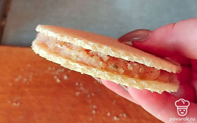 На вафельный кружок выложите фарш и накройте другим вафельным кружком.