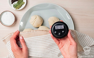 Замесите эластичное тесто. Высыпьте муку в широкую емкость, сделайте в ней небольшую лунку, положите соль и разбейте туда яйца. Начните замешивать тесто, добавляя по чуть-чуть воду, пока тесто не станет мягким и податливым. Разделите его на 6 частей, одна из которых должна быть больше остальных. Скатайте шарики, выложите их на тарелку и накройте сухим полотенцем. Уберите тесто в холодильник на 30 минут.