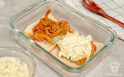 Приготовьте тосты. Аккуратно выложите на поджаренный хлеб маринованные грибы. Густо покройте их сверху сырно-чесночной массой. Выложите на противень и поставьте в духовку на 10-15 минут.