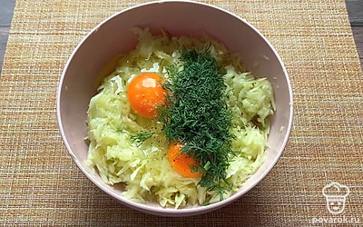 Добавьте 2 яйца к кабачкам. Добавьте туда же нарезанную зелень. Посолите и поперчите. 