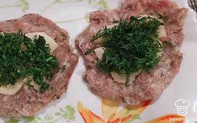 Часть фарша сформируйте в кружок, положите сыр и укроп, сверху закройте вторым кружком, сформируйте котлету.