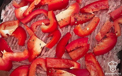 На получившийся пласт из фарша положите болгарский перец и помидоры.