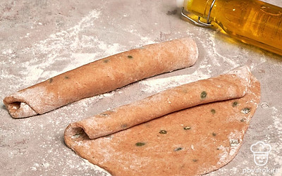 Приступите к разделке теста. Выложите тесто на поверхность, покрытую небольшим слоем муки, обомните, поделите на две части. Из каждой сформируйте багеты. Дайте расстояться в течение получаса. Заготовки предварительно накройте пищевой пленкой.