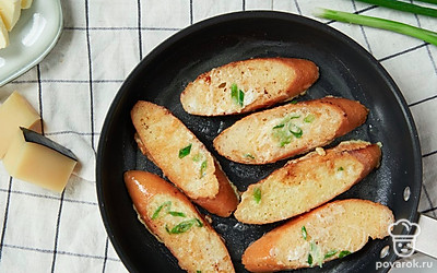 Приготовьте гренки с яйцом и луком. Сковороду поставьте на средний огонь. Выложите масло. Обмакните каждый кусочек хлеба в яичную смесь и обжарьте с двух сторон до образования золотистой корочки.