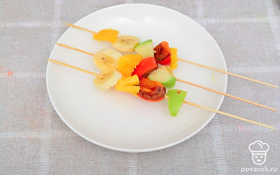 Очистьте вишню от косточки и измельчите ее. Нарежьте фрукты на удобные для поглощения кусочки. Нанизайте фрукты на шпажки.