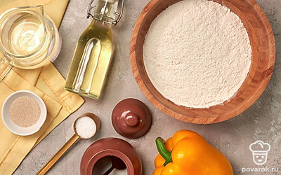 Отмерьте необходимое количество продуктов. Муку просейте через сито. Воду подогрейте. Болгарский перец вымойте, удалите плодоножку, семена и мембраны. Нарежьте небольшими кусочками. Противень застелите пергаментной бумагой. Приготовьте овощной салат для подачи.