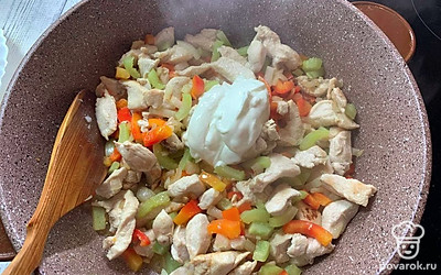 Затем добавьте сметану и соль-перец по вкусу и продолжайте жарить курицу с овощами еще в течение 5-7 минут.
