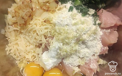В тару с курицей помещаем натертый сыр, яйца, йогурт и муку. Натираем чеснок.
