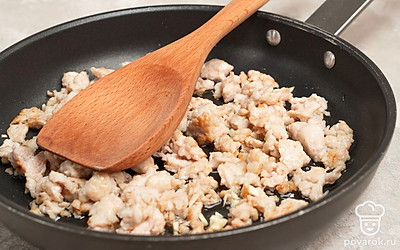 Приготовьте фарш. Сковороду поставьте на огонь, влейте растительное масло, разогрейте и выложите нарезанный лук. Обжарьте и добавьте куриный фарш. Непрерывно помешивая, разминайте до испарения всей влаги. Приправьте чесноком, солью, перцем и снова перемешайте.