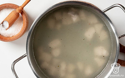 Приготовьте бульон. Налейте в кастрюлю три стакана воды, вскипятите воду и положите в нее куриное филе. Посолите и добавьте черный перец. Варите мясо 20 минут на среднем огне, снимая пену. После этого снимите кастрюлю с плиты и дайте бульону настояться еще 15 минут.