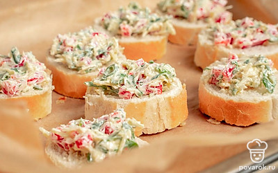 Сделайте гренки. Багет нарежьте на продолговатые кусочки 1,5 см толщиной. Выложите начинку на кусочки и разместите их на противне. Установите температуру духовки 180 градусов и поставьте в нее гренки на 15 минут.