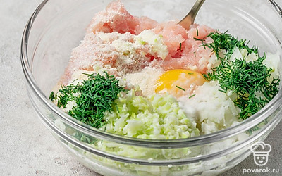 Займитесь подготовкой котлетной массы. Для этого измельчите филе индейки в блендере, выложите в глубокую миску. Аналогично поступите с кабачком и луком. Объедините мясную и овощную основы. Добавьте яйцо, крахмал, манку, зелень, соль и перец. Активно выместите. Отправьте котлетную массу на 30 минут в холодильник.